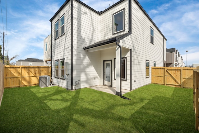 rear view of property featuring central air condition unit, a yard, a gate, and a fenced backyard