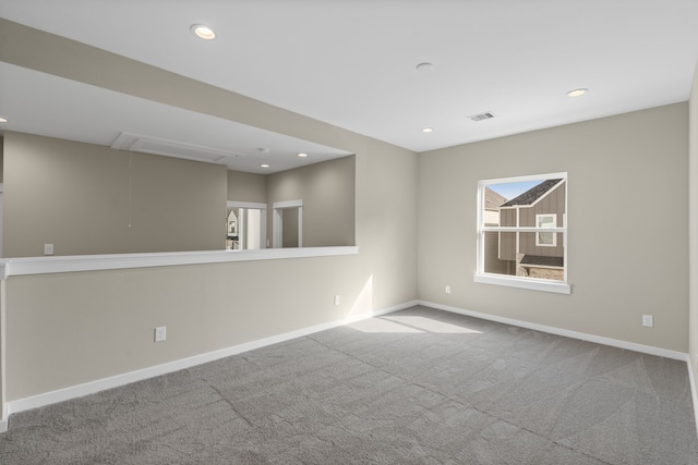 carpeted spare room featuring recessed lighting, baseboards, visible vents, and attic access