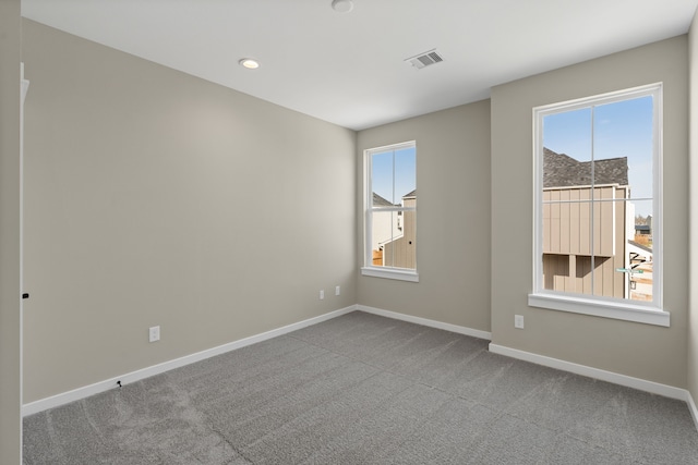 unfurnished room featuring baseboards, visible vents, and a healthy amount of sunlight