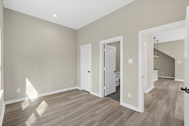 interior space with an inviting chandelier, baseboards, and wood finished floors