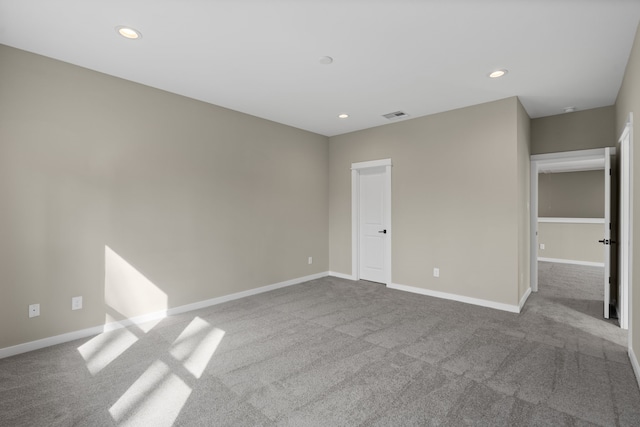 carpeted spare room featuring baseboards, recessed lighting, and visible vents