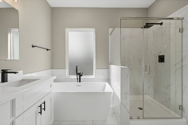 full bathroom featuring wainscoting, vanity, a marble finish shower, marble finish floor, and a soaking tub