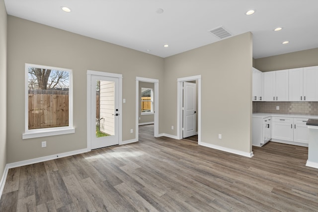 unfurnished living room with visible vents, recessed lighting, baseboards, and wood finished floors