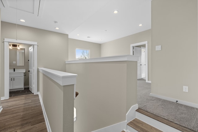 hall with recessed lighting, baseboards, an upstairs landing, and attic access