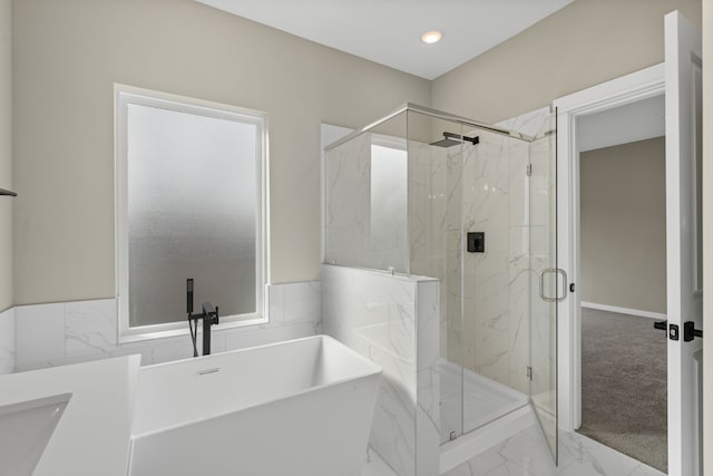 full bath with marble finish floor, a marble finish shower, a freestanding tub, and a wealth of natural light