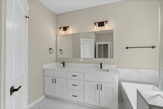 bathroom featuring double vanity, a sink, marble finish floor, and a soaking tub