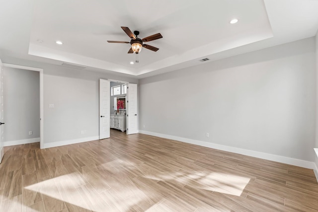 unfurnished room with visible vents, baseboards, recessed lighting, a raised ceiling, and a ceiling fan
