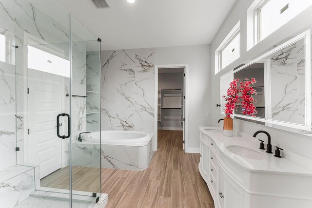 full bath featuring a sink, a marble finish shower, a walk in closet, and visible vents
