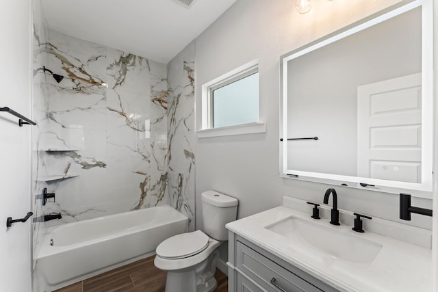 bathroom featuring vanity, wood finished floors, bathing tub / shower combination, and toilet