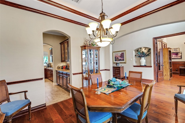 6119 Lofty Ln, Spring, TX 77379 - dining room with a chandelier, dark wood finished floors, arched walkways, and crown molding