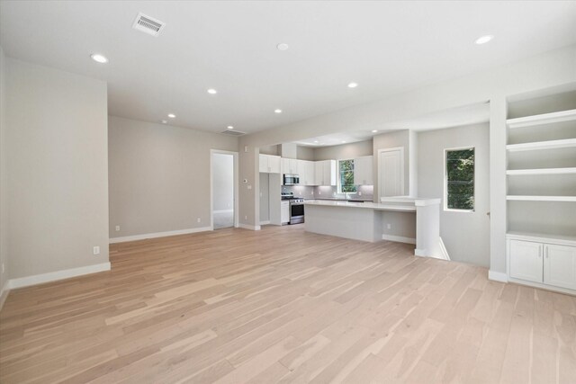 540 Janisch Rd Unit F, Houston, TX 77018 - unfurnished living room with recessed lighting, baseboards, visible vents, and light wood-style flooring