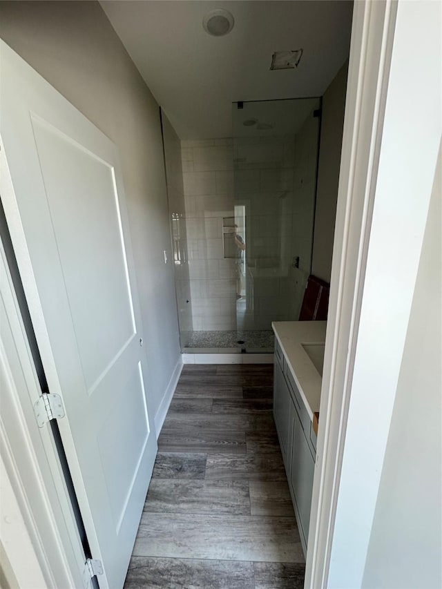 1411 30th St, Galveston, TX 77550 - bathroom featuring vanity, tiled shower, and wood finished floors