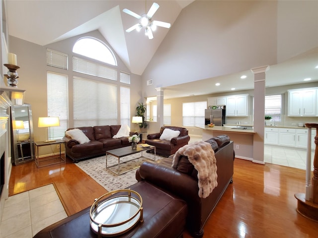 5439 Emerald Pointe Ln, Sugar Land, TX 77479 - living room with visible vents, decorative columns, high vaulted ceiling, a ceiling fan, and light wood-style flooring