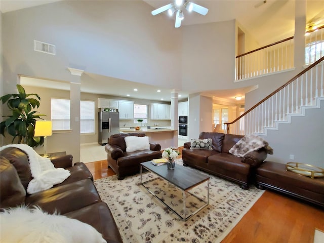 5439 Emerald Pointe Ln, Sugar Land, TX 77479 - living area featuring a towering ceiling, ornate columns, light wood-style flooring, and visible vents