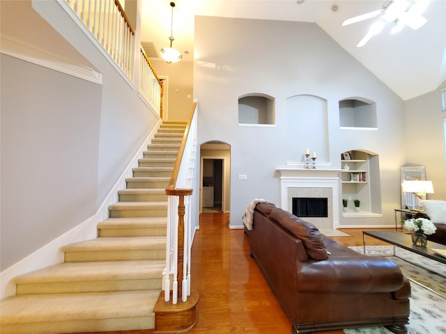 5439 Emerald Pointe Ln, Sugar Land, TX 77479 - living room featuring a ceiling fan, high vaulted ceiling, built in shelves, and wood finished floors