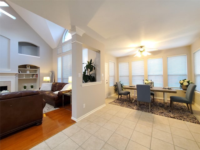 5439 Emerald Pointe Ln, Sugar Land, TX 77479 - tiled dining room with ceiling fan, a tiled fireplace, baseboards, and lofted ceiling