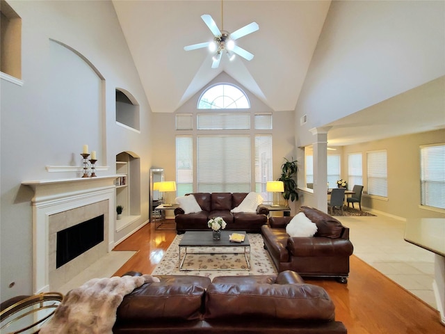 5439 Emerald Pointe Ln, Sugar Land, TX 77479 - living room with decorative columns, wood finished floors, ceiling fan, built in shelves, and a tiled fireplace