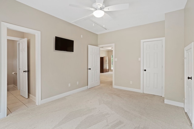unfurnished bedroom with baseboards, attic access, and light colored carpet