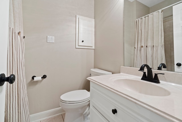 bathroom featuring vanity, tile patterned flooring, baseboards, and toilet