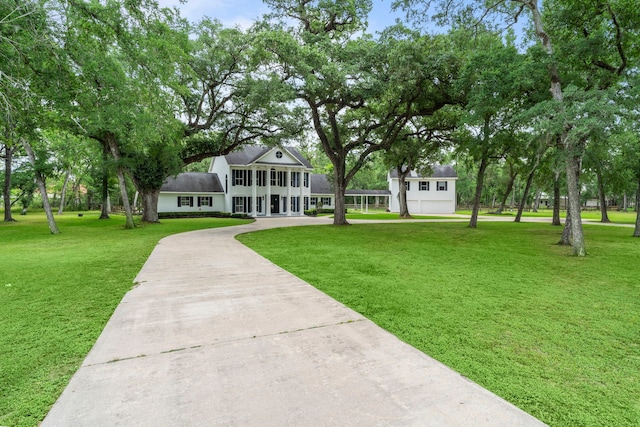 surrounding community featuring concrete driveway and a yard
