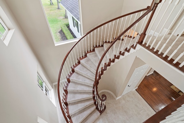 staircase featuring tile patterned floors and a towering ceiling