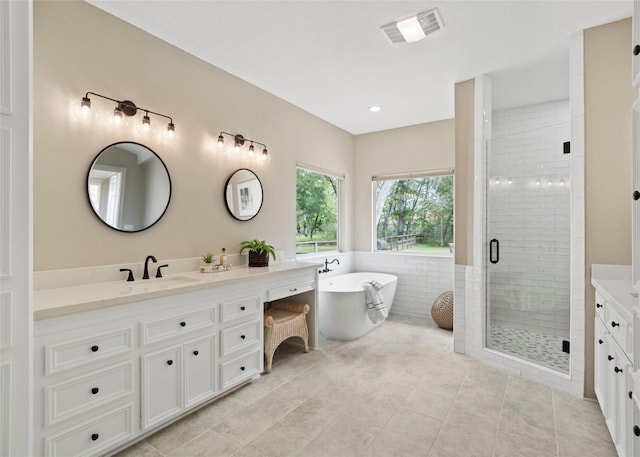 bathroom with visible vents, a freestanding bath, tile patterned flooring, a stall shower, and vanity