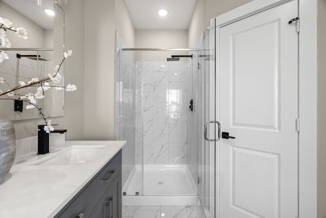 bathroom with recessed lighting, a marble finish shower, marble finish floor, and vanity