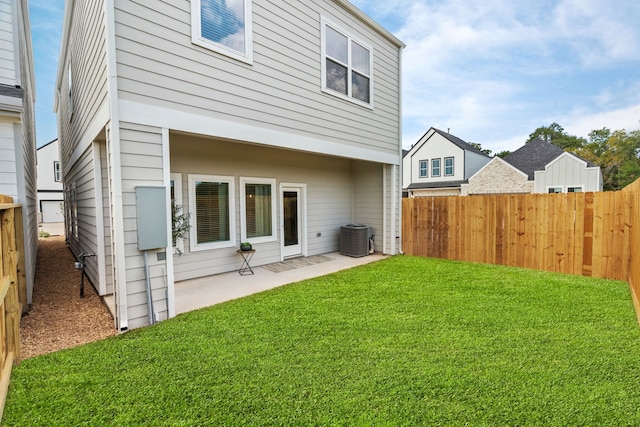 back of property featuring a yard, central AC, a fenced backyard, and a patio area