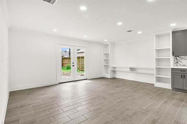 unfurnished living room featuring baseboards, ornamental molding, and light wood finished floors