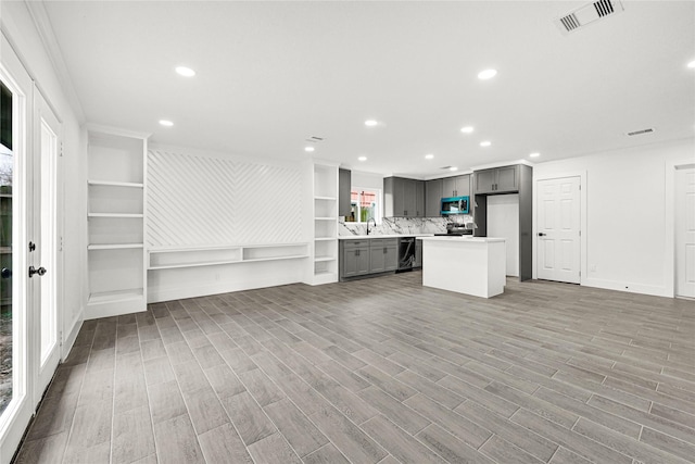 kitchen with gray cabinets, stainless steel appliances, open floor plan, and visible vents
