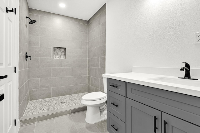 full bath with vanity, recessed lighting, a tile shower, and toilet