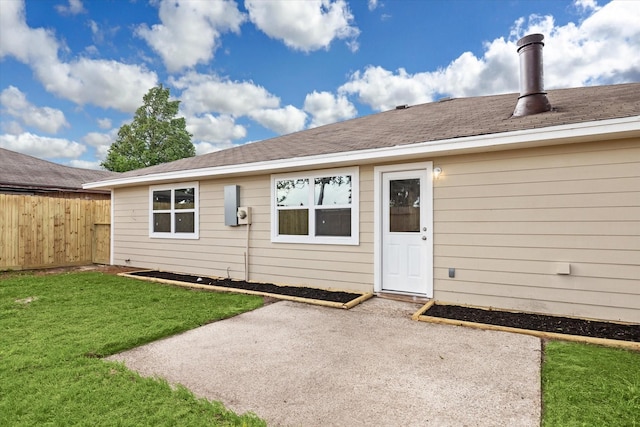 back of property with fence, a patio, and a lawn