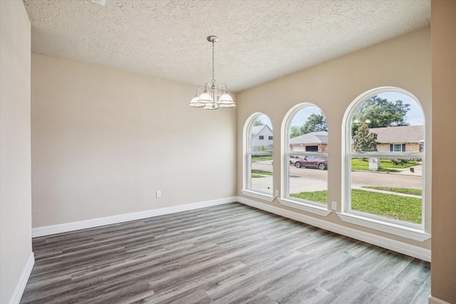 3519 Hombly Rd, Houston, TX 77066 - spare room with a textured ceiling, dark wood-style floors, a chandelier, plenty of natural light, and baseboards