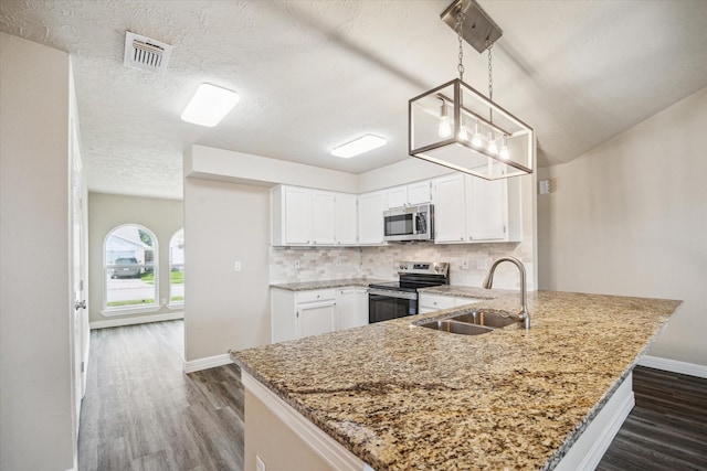 3519 Hombly Rd, Houston, TX 77066 - kitchen featuring appliances with stainless steel finishes, a sink, a peninsula, dark wood finished floors, and a textured ceiling