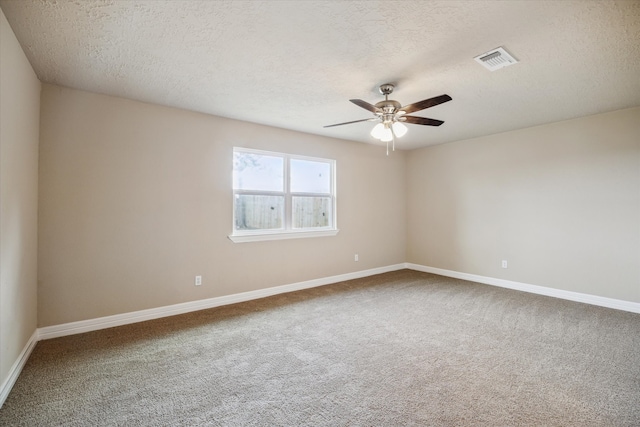 unfurnished room with a ceiling fan, carpet flooring, a textured ceiling, and visible vents
