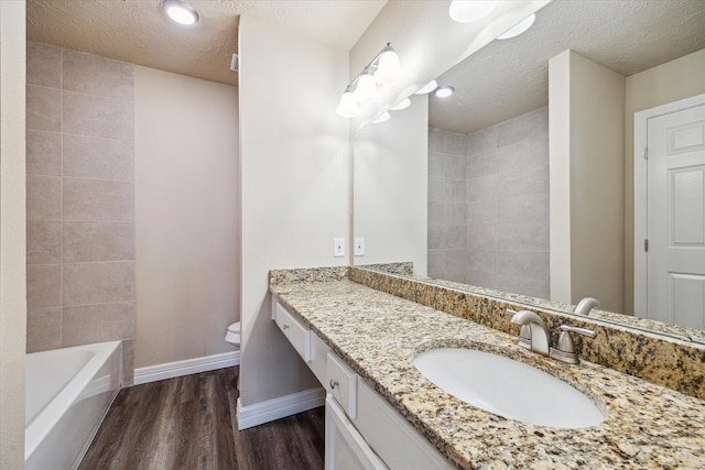 3519 Hombly Rd, Houston, TX 77066 - full bath with wood finished floors, toilet, baseboards, a textured ceiling, and vanity