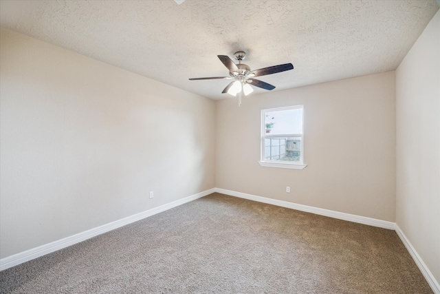 carpeted spare room featuring baseboards, a ceiling fan, and a textured ceiling