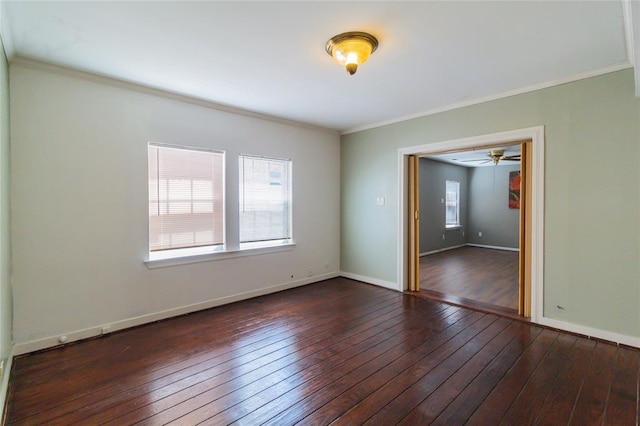 empty room with crown molding, baseboards, and dark wood finished floors