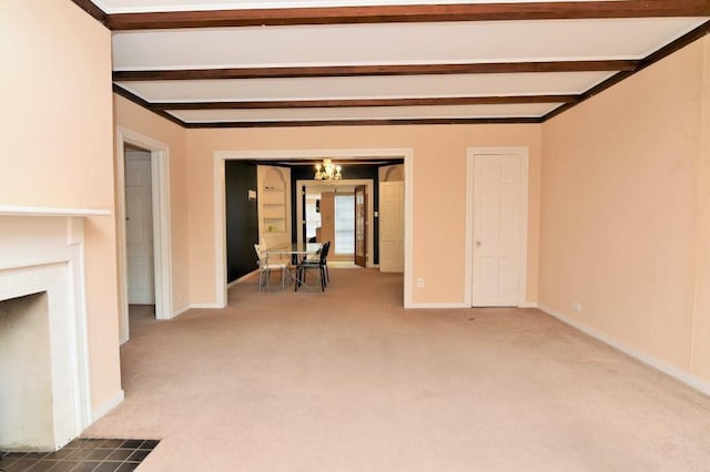 unfurnished living room featuring baseboards, carpet flooring, and beam ceiling