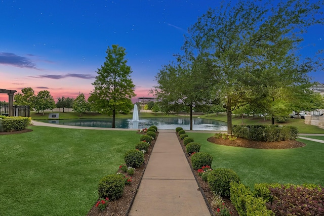 view of home's community with a water view and a yard