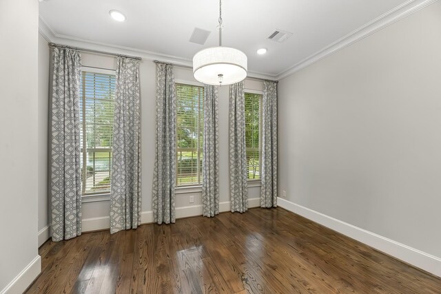 unfurnished dining area with visible vents, ornamental molding, baseboards, and wood finished floors