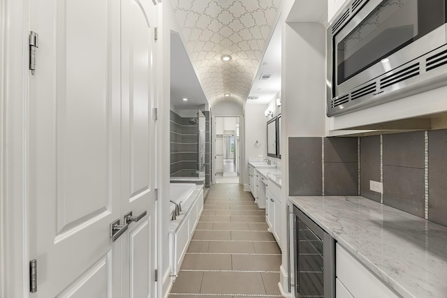 bathroom with vanity, visible vents, wine cooler, tile patterned floors, and a shower stall