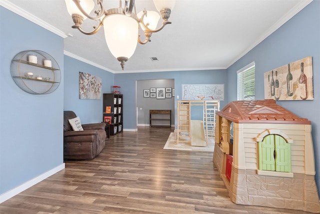interior space featuring an inviting chandelier, crown molding, wood finished floors, and visible vents