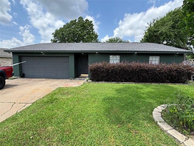 single story home featuring a garage, concrete driveway, brick siding, and a front yard