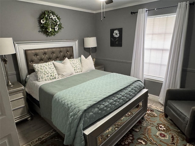 bedroom featuring multiple windows, ornamental molding, and wood finished floors