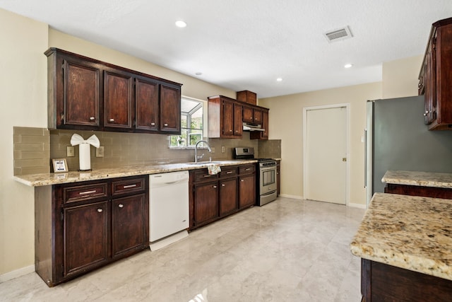 40206 Colfax Rd, Magnolia, TX 77354 - kitchen with stainless steel appliances, under cabinet range hood, backsplash, a sink, and light stone counters