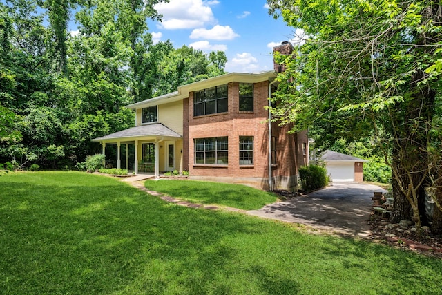 40206 Colfax Rd, Magnolia, TX 77354 - view of front facade with a chimney, a front yard, a detached garage, brick siding, and an outdoor structure