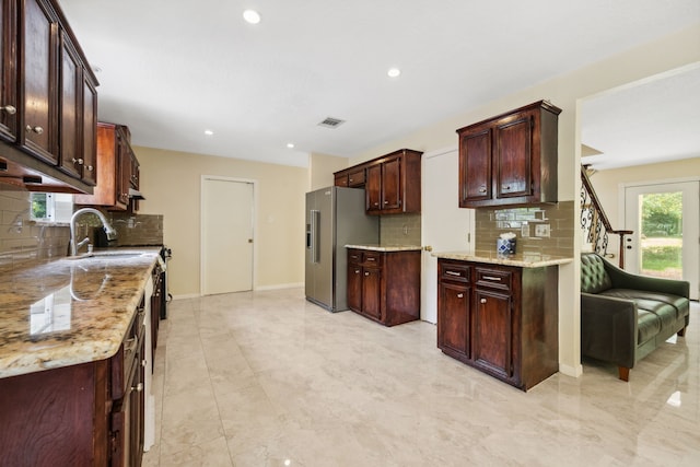 40206 Colfax Rd, Magnolia, TX 77354 - kitchen with stainless steel refrigerator with ice dispenser, decorative backsplash, a sink, recessed lighting, and light stone countertops