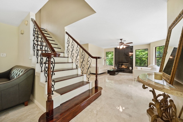 40206 Colfax Rd, Magnolia, TX 77354 - staircase featuring a fireplace, marble tiled flooring, and ceiling fan
