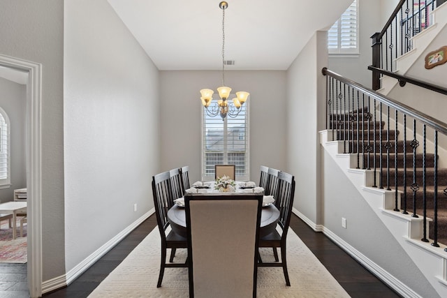 dining space with baseboards, a chandelier, dark wood finished floors, and stairway